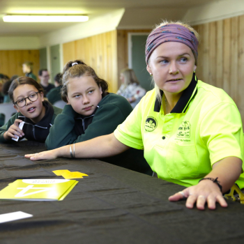 Volunteer role model sits in uniform with students