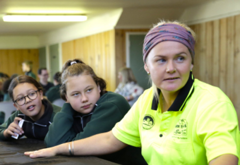 Volunteer role model sits in uniform with students